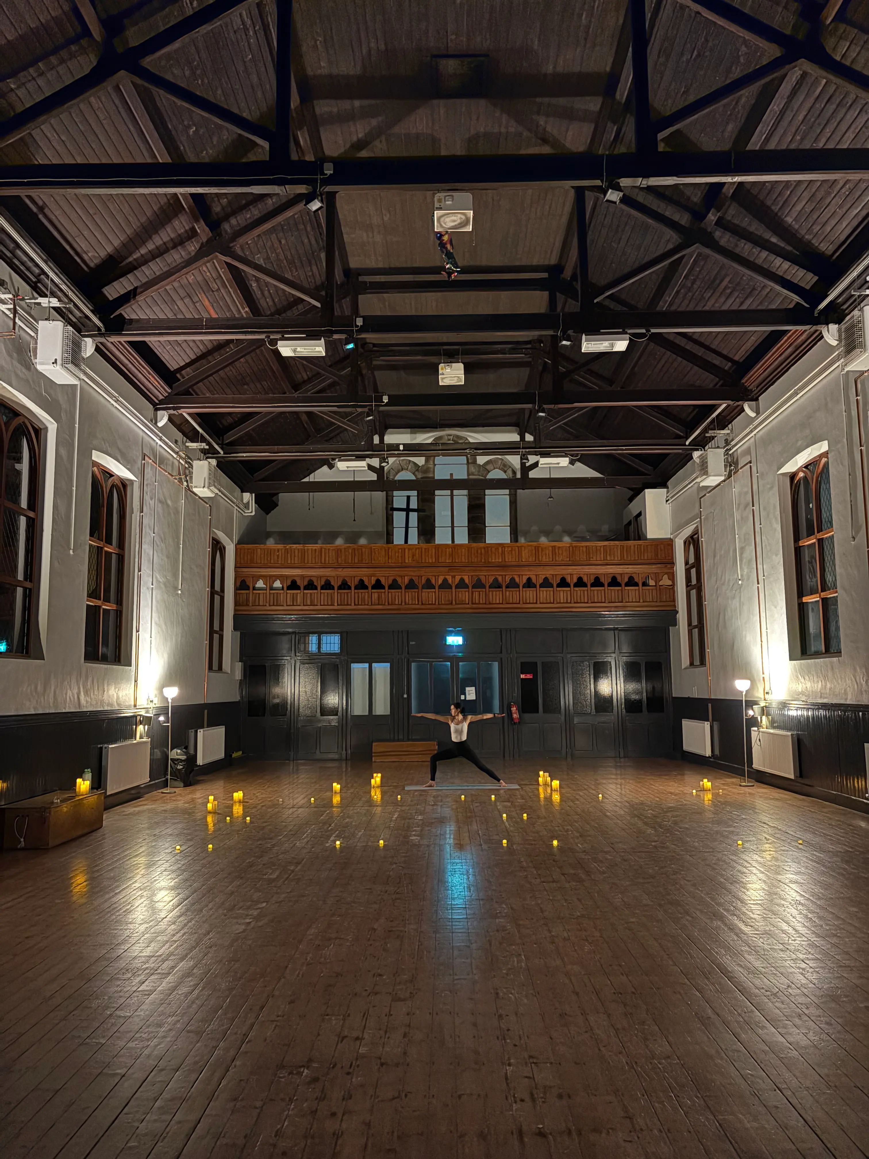 Candlelit yoga session in the high-ceilinged hall